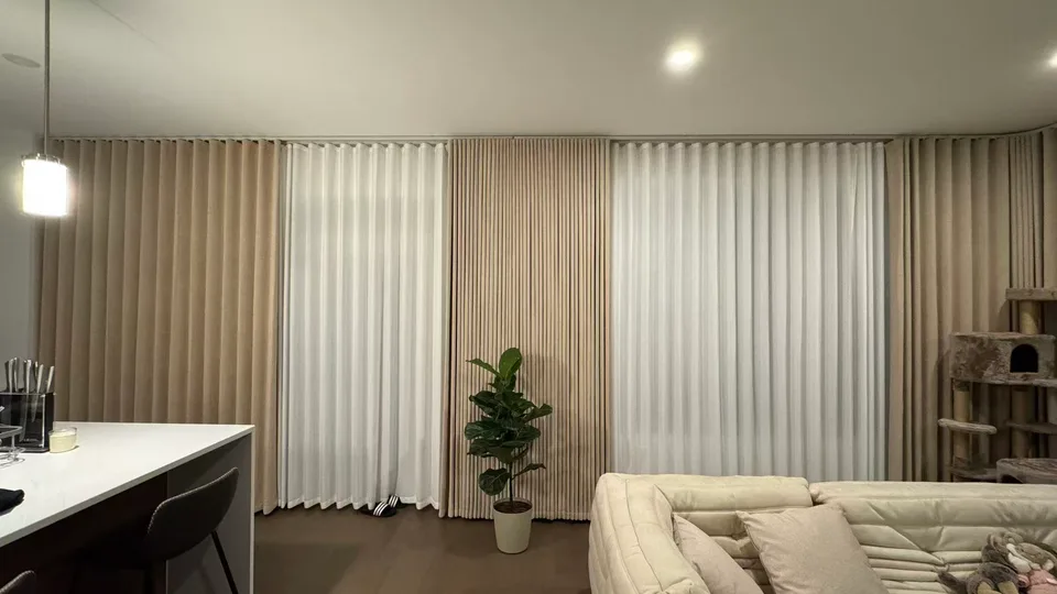 Floor-to-ceiling layered curtains behind a sofa and indoor plant