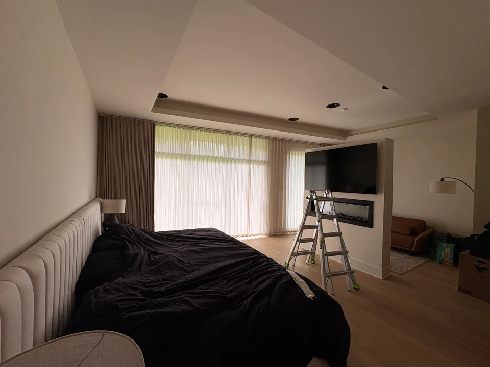 Bedroom curtain installation in progress, with a ladder beside the window